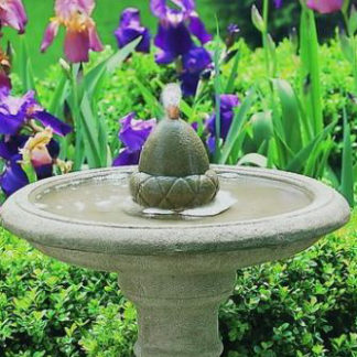 stone acorn bird bath fountain in flower garden