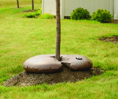 Donut shaped brown bag filled with water surrounding a tree trunk